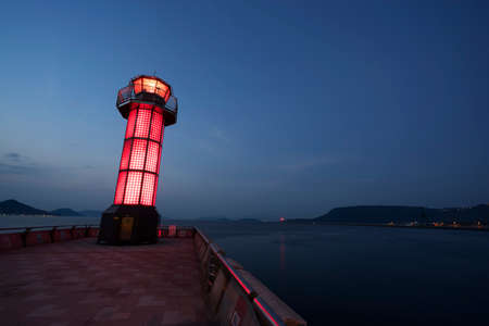 Wide angle of red lighthouse on dark blue sky background.の写真素材