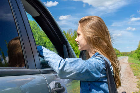 A young girl, a teenager, hitchhiking stopped the car for a trip, talking to the driver about the...
