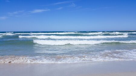 The sea is agitated. Beautiful waves on a sandy beach. Sea, waves, and blue sky.の写真素材