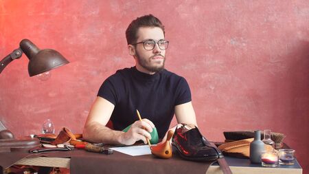 serious shoemaker, in the process of making shoes.