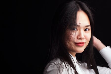 girl with an Asian appearance poses for the camera on an isolated background.