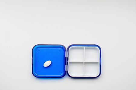 The photo shows an empty box with cells for capsules and tablets.