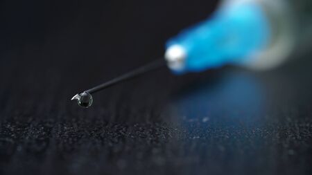 macro drop on the needle of a medical syringe.の写真素材