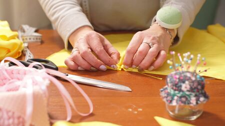 The seamstress works in her workshop and creates stylish things.