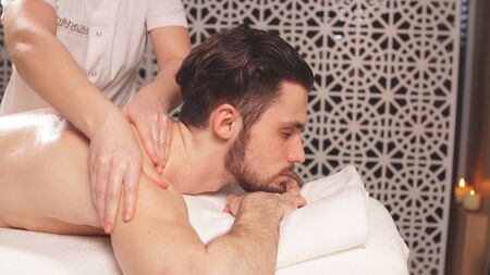 Photos of womens hands giving a man a massage, close- up.の写真素材