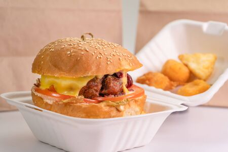 Paper bag and Burger box on the table isolated on a white background, close-up.