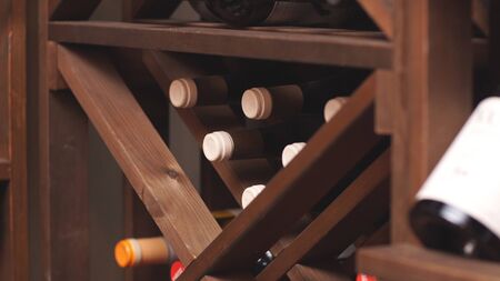Bottles of wine are stored on shelves in the basement of the wine store. close up.