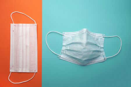 Medical protective face mask, curved face shape on isolated blue background, clean new medical mask on isolated orange background. virus protection,の写真素材