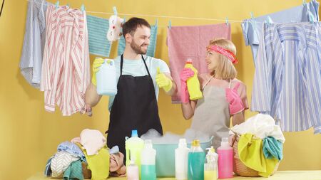 pretty blonde and a handsome brunette with a beard give a thumbs up and look at the camera. Family ads for detergents and washing powder. The concept of advertising.の写真素材