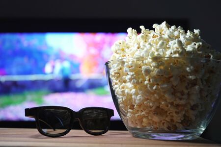 popcorn 3D glasses and TV in the background. Evening movie viewing at home on self-isolation.の写真素材