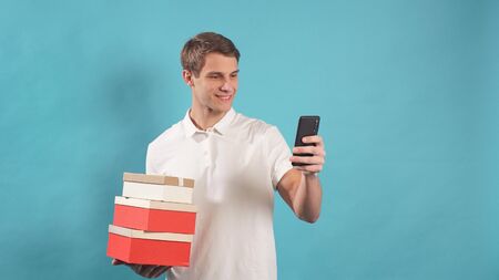 Portrait of a young courier on an isolated background with ready-made customer orders. Express...