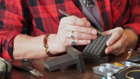 male jeweler works at his workplace in a jewelry workshop. Favorite work.