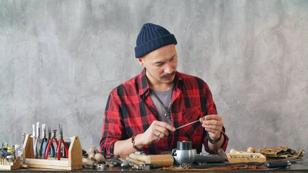 Master jeweler makes jewelry in the workplace. work of a jeweler close-up.の写真素材