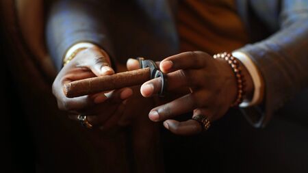 In the hands of an African-American cigar close-up. close-up of an African-American mans hands.の写真素材