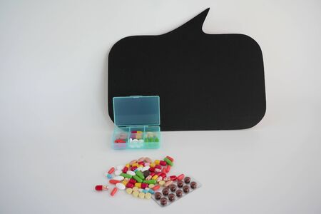 Medical medications, a bunch of colorful pills, and a plastic box for taking pills every day. A copy...