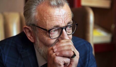 Thoughtful, serious look of the entrepreneur, the owner of the company, elegantly dressed in a...