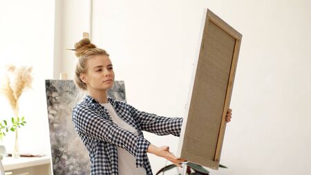 Portrait of the artist holding his completed painting on canvas.の写真素材