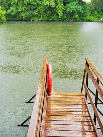 Rain on the lake. morning rainy landscape and pier on the lake.の写真素材