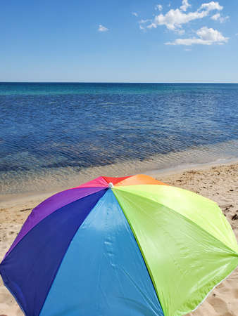 top view of a colorful beach umbrella against the sun against the background of the azure sea and sky.の写真素材