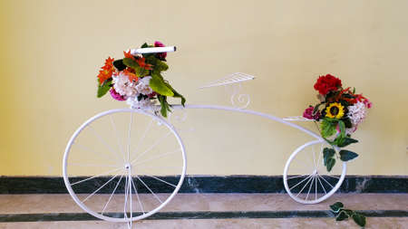 Decorative decoration, design solution in the form of a bicycle, a white decorative bicycle decorated with flowersの写真素材