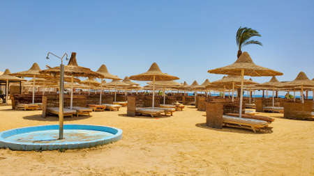 Straw beach umbrellas close-up from the sun against a clear blue sky with palm trees. The Red Sea. Egypt, Africaの写真素材