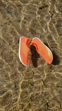 Shoes for swimming in the sea, on the rocks in the water on the beach. Close-up of water shoes in...
