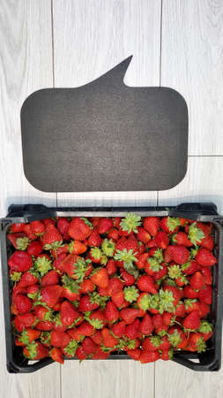 Background of ripe strawberries in a box. A box of red juicy strawberries in close-up. Top view.の写真素材