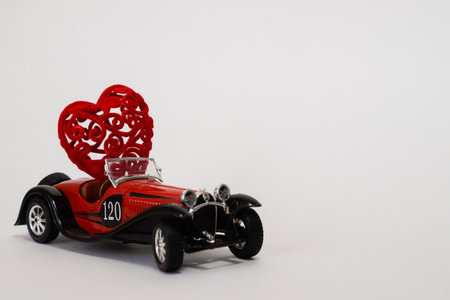 Volgograd, Russia-January 17, 2021. A small red retro bugatti car carries a heart. The Concept Of...