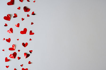 Little paper hearts in the vertical direction on a white background. Valentine's day.