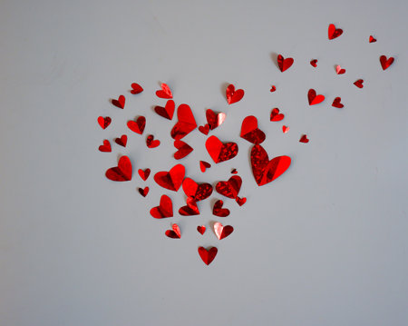 Background of many red small hearts forming one big heart isolated on a white background. The concept of Valentine's Day.の写真素材