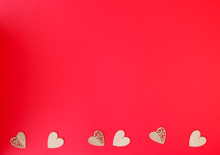 Beautiful little wooden hearts on red backgroundの写真素材