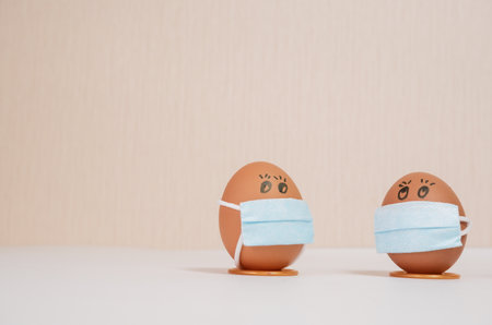 Easter eggs with virus protection concepts. Easter eggs in a medical mask to decorate the Easter...