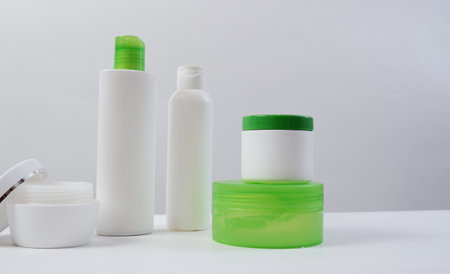 Empty bottles and tubes with disc press cap for branding and mockup. space for text on the left.