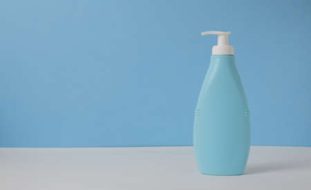 Empty blue mockup jar and dispenser bottle of cosmetic products against blue background. space for text to the left.の写真素材