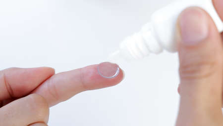 Contact lens on finger on a blue backgroundの写真素材