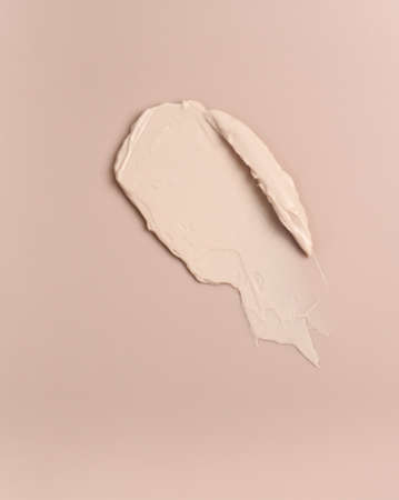 Pink creamy foundation texture background. A smear of ivory foundation on a pink background.の写真素材