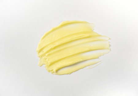 Cosmetic products creamy yellow stain texture on a white background. The texture of natural cosmetics hair mask, cream, scrubの写真素材