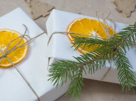 New Year's composition. Close-up gift boxes, dry orange orange slices, fir branches. Cozy Christmas conceptの写真素材