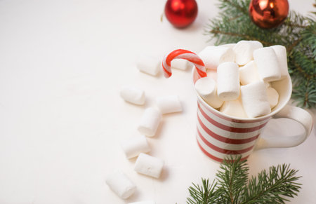 Traditional hot chocolate with marshmallows and lollipops on a white textured background. Christmas drink themeの写真素材