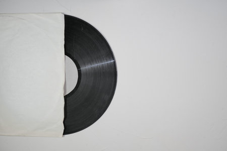 Old vinyl record in paper case on white marble background.の写真素材