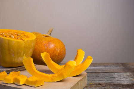Ripe pumpkin and its slices on a cutting boardの写真素材