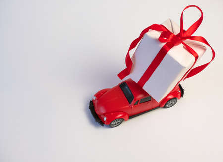 Red retro toy car delivering Christmas or New Year gifts on the roof on a white background, top viewの写真素材