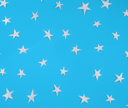 Blue background with silver stars. Pattern.