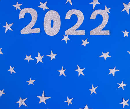 silver glitter shapes of numbers 2022 with stars on blue background, minimalism new year concept. Place for text.の写真素材