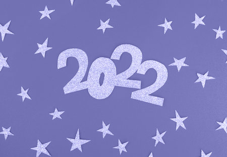Lilac glittering numbers 2022 and stars on a pale purple background with place for text. New year...