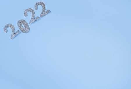 Happy New Year 2022. Christmas background with silver glittering numbers 2022 on light blue background. View from above. Place for your text.の写真素材