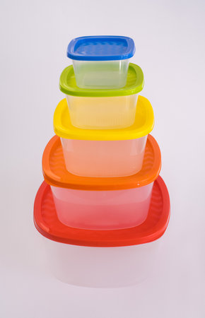 Pyramid of food plastic containers with colorful lids on white background.の写真素材