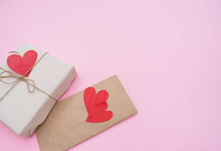 Valentines day gift on pink background with red homemade hearts valentines. Love concept.