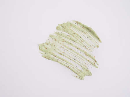 A sample of a natural green scrub on a white background. Peeling cream with microcapsules. Smear of...
