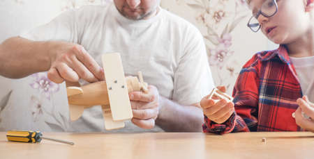 Happy father's day and childhood concept. Father and son-boy in glasses work with hand tools, using...